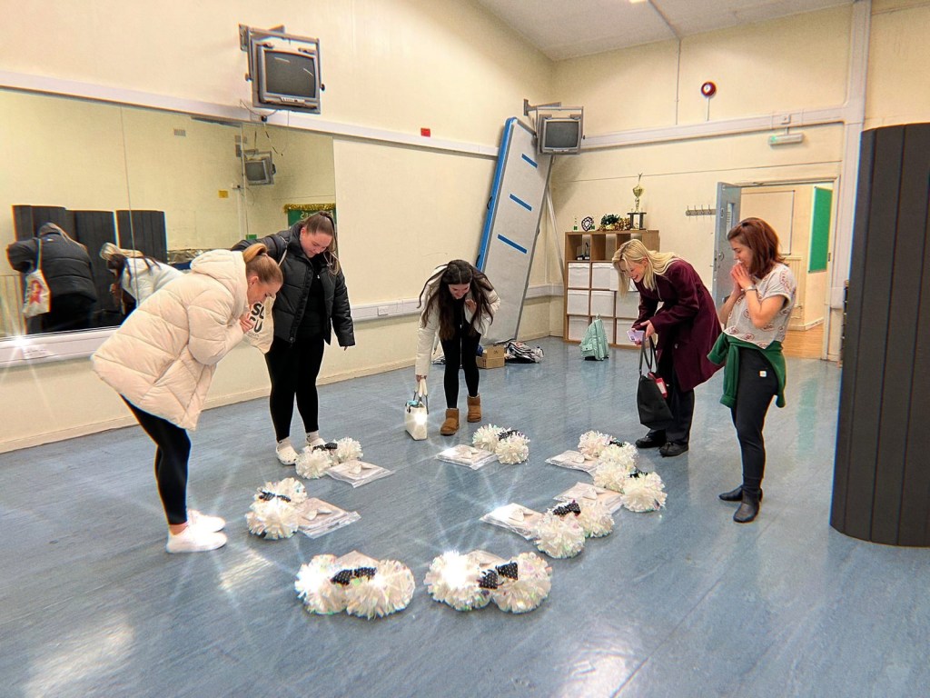 The cheerleading team getting their new bows and uniform